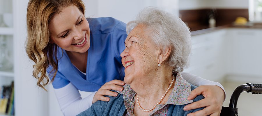 Portrait Of Nurse And Her Senior Client On Wheelchair.